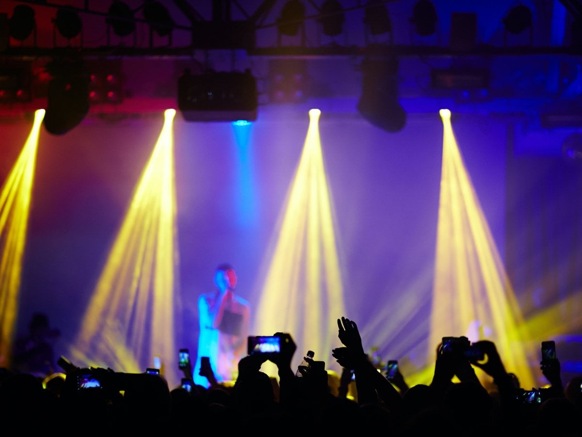 Scen med belysning och publik som tittar på konsert