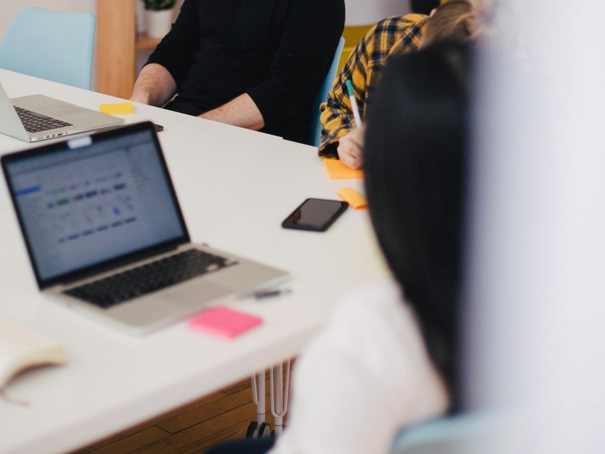 Två personer sitter vid ett mötesbord. 