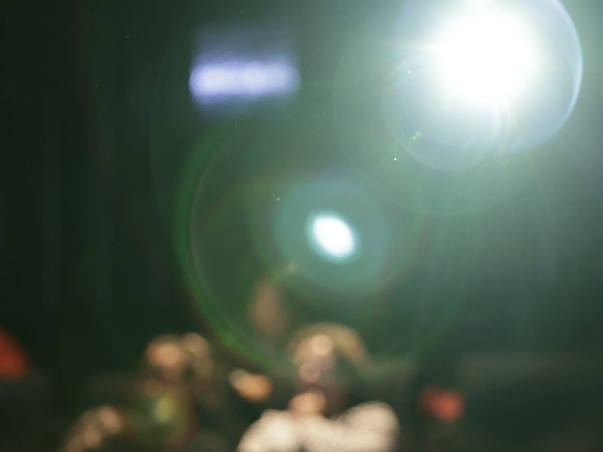 Publik i en salong. Bilden är oskarp och en strålkastare reflekterar ljus i förgrunden.