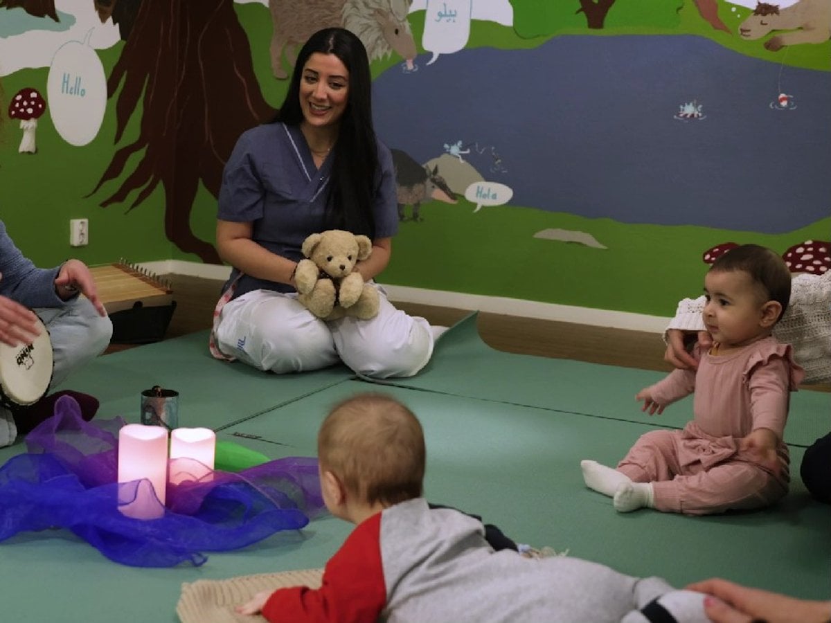 Barn på golvet och sköterska i musikterapi på BVC.