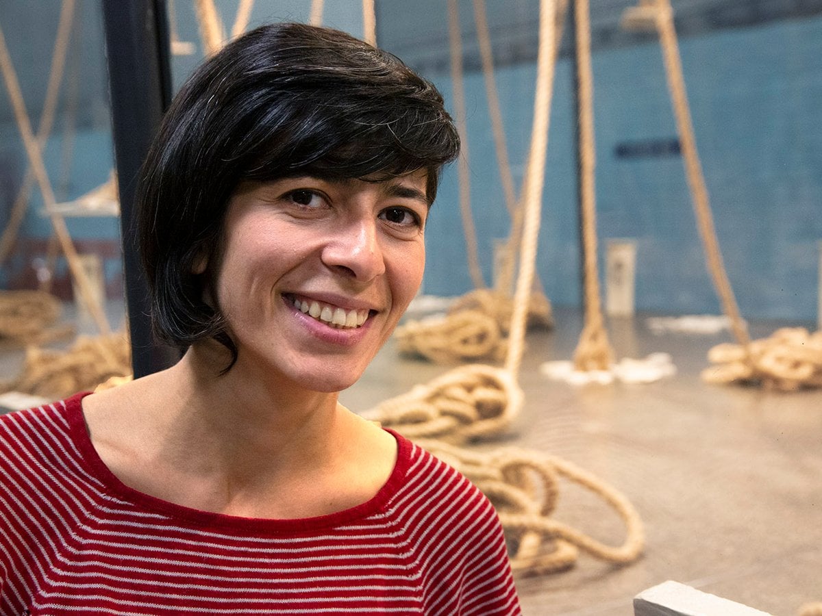 Samaneh ler mot kameran. I bakgrunden ser man montern där det hänger rep från taket,