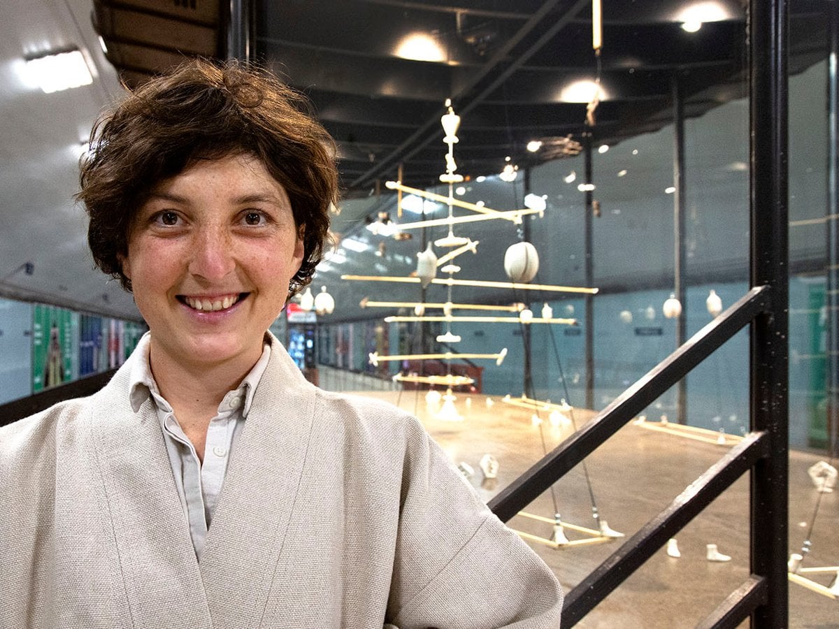 Laura framför montern. I taket hänger en mobil med pinna och små gipsobjekt.