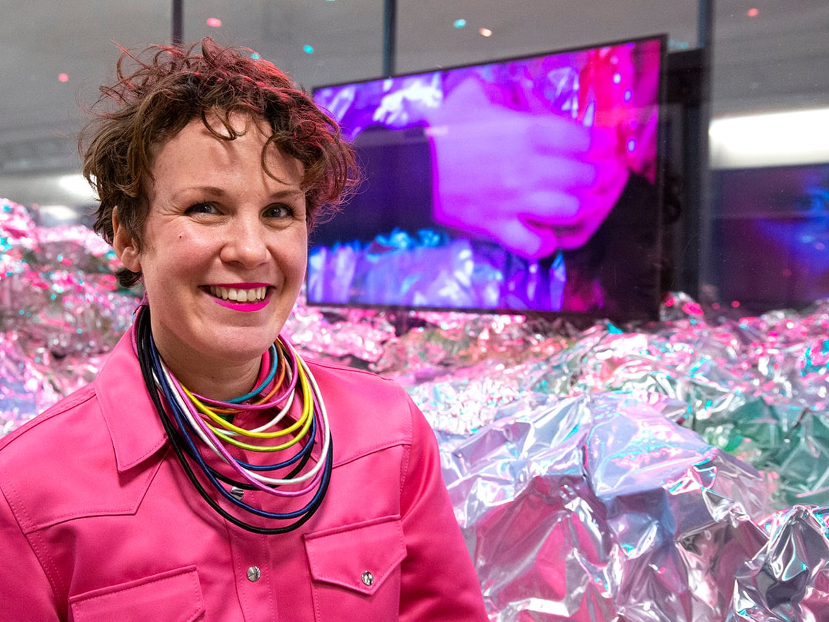 Alexandra ler mot kameran framför en glittrande monter