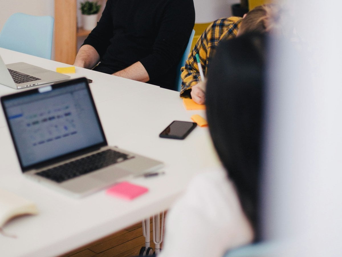 Två personer sitter vid ett mötesbord. 