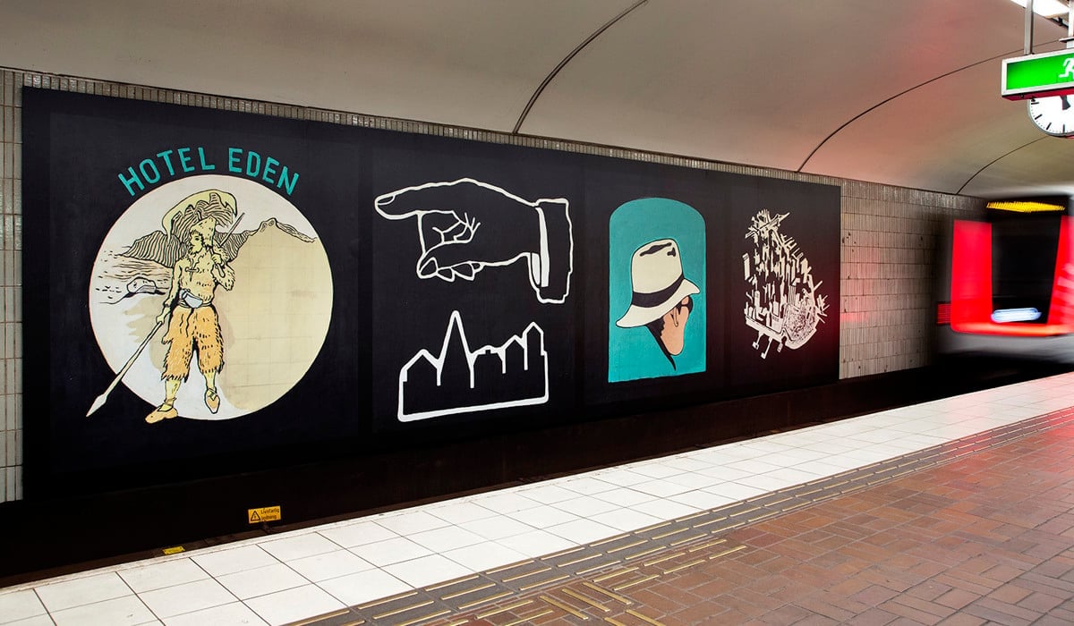 Lån bild utmed tunnelbanevägg med illustrationer.