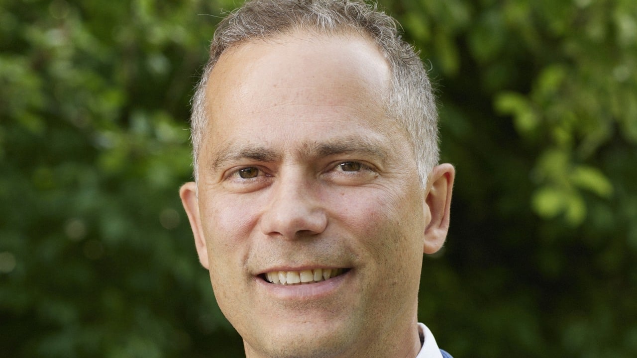 Bild på man med grönska i bakgrunden