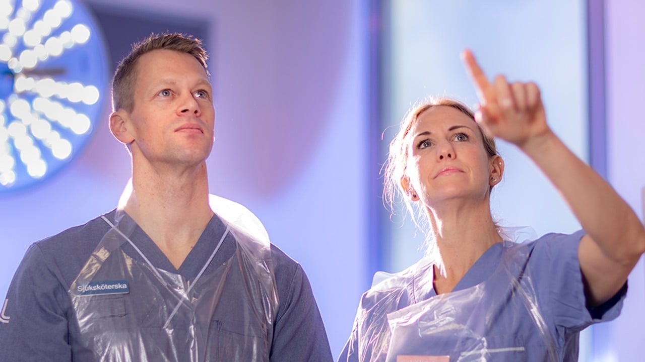 Två medarbetare observerar en skärm. Kvinna pekar mot skärmen.