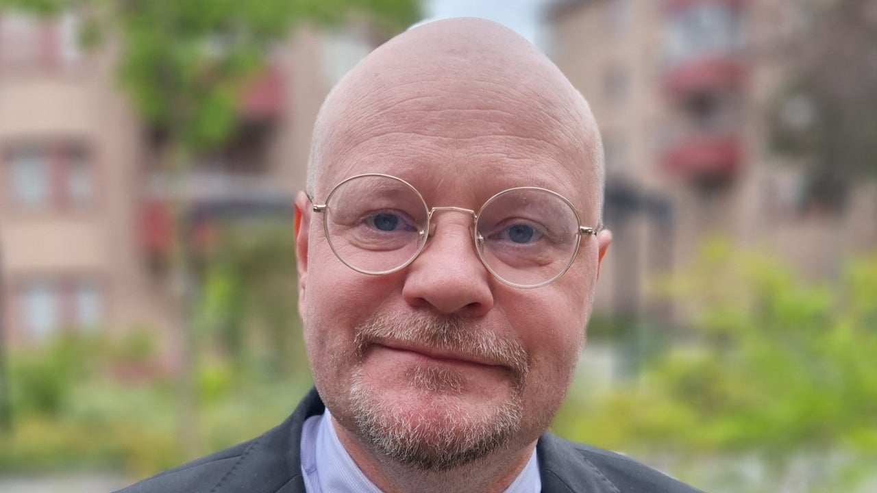 Man med glasögon tittar in mot kameran