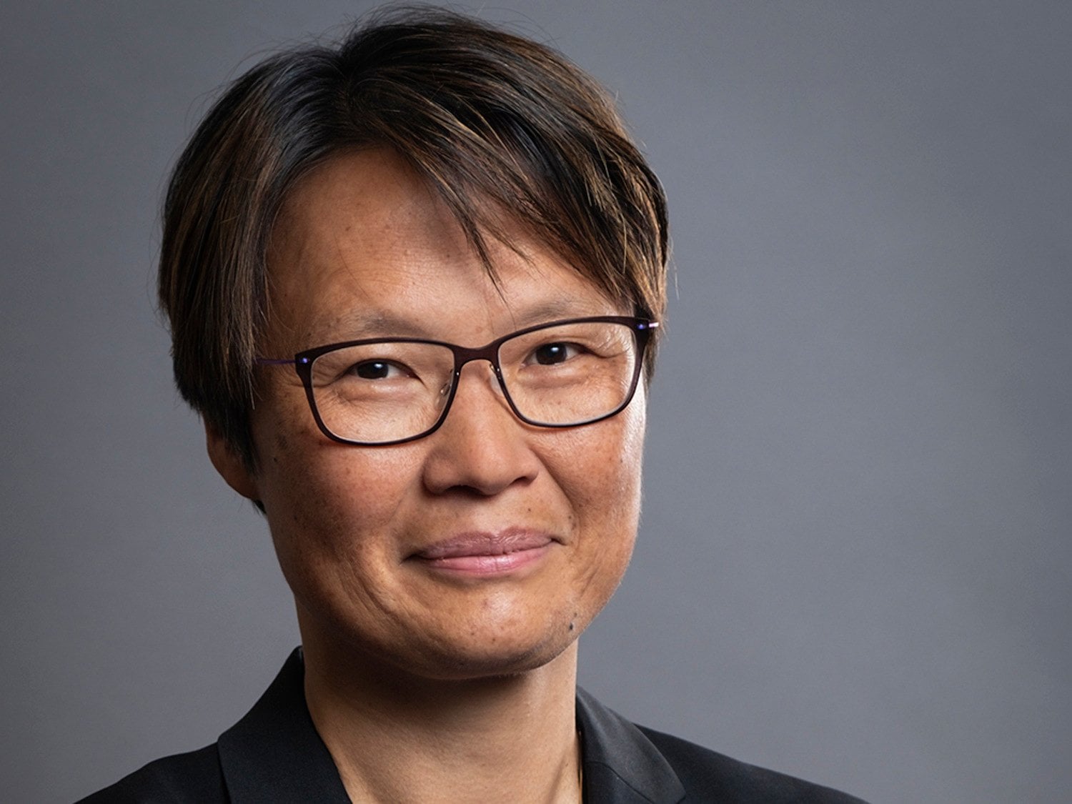 Kvinna med glasögon tittar in mot kameran