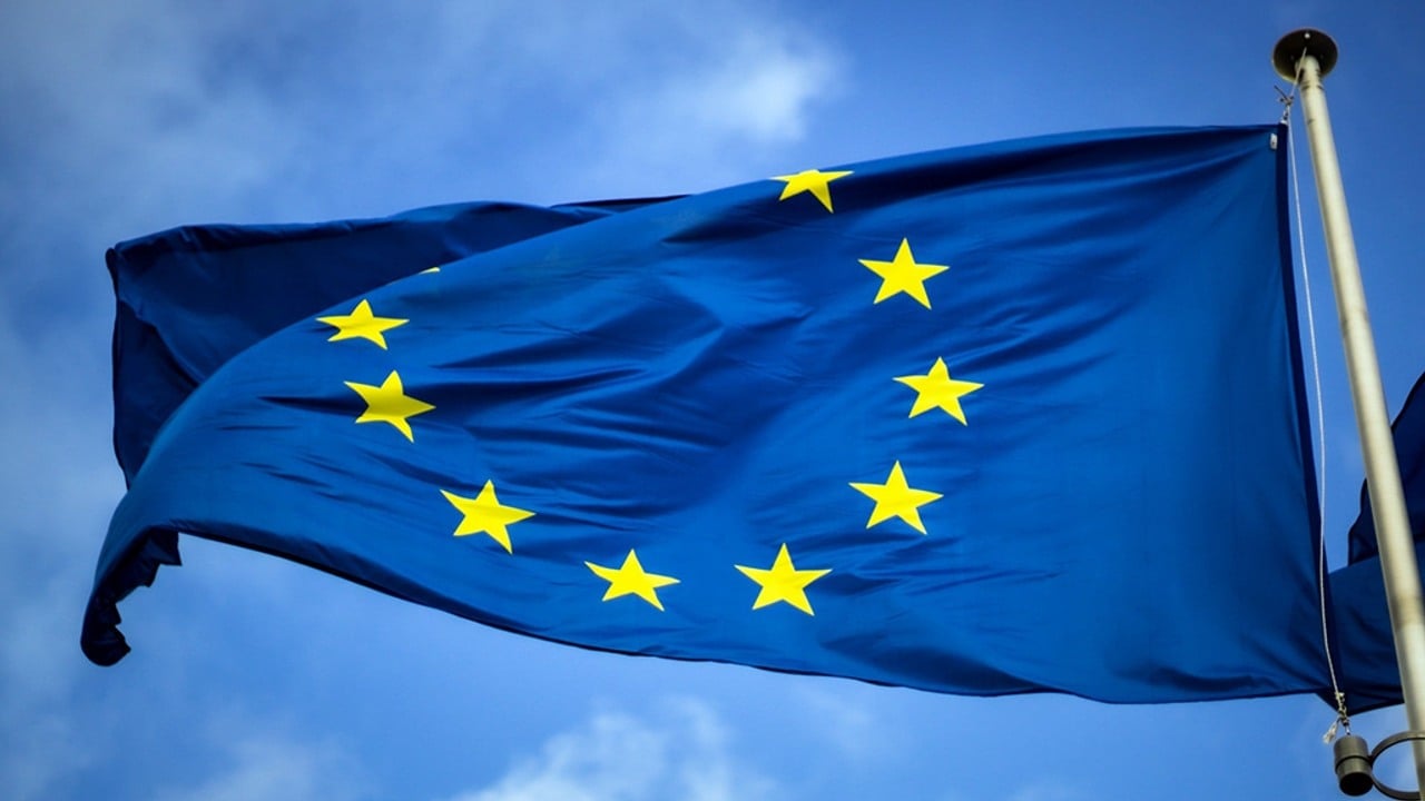 En EU-flagga vajrar med blå himmel i bakgrunden