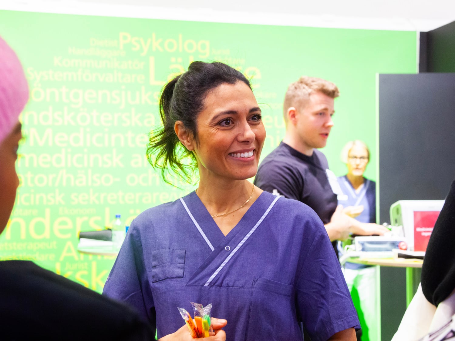 Foto på ortodontiassistent Houda Bahri som står och pratar med besökare på Sacos studentmässa 2022