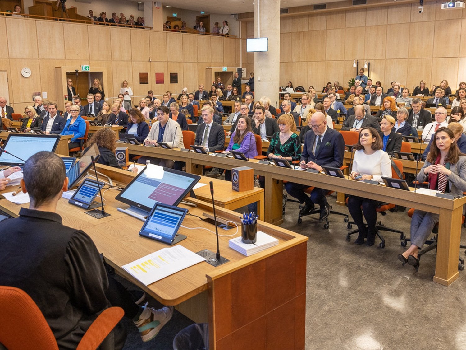 Människor som sitter uppradade med datorer framför sig. 