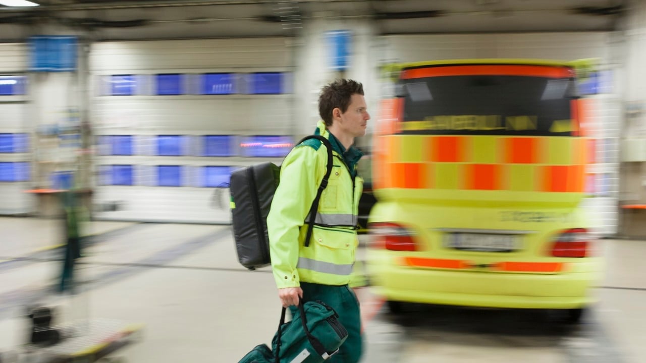 ambulanspersonal framför ambulansbil