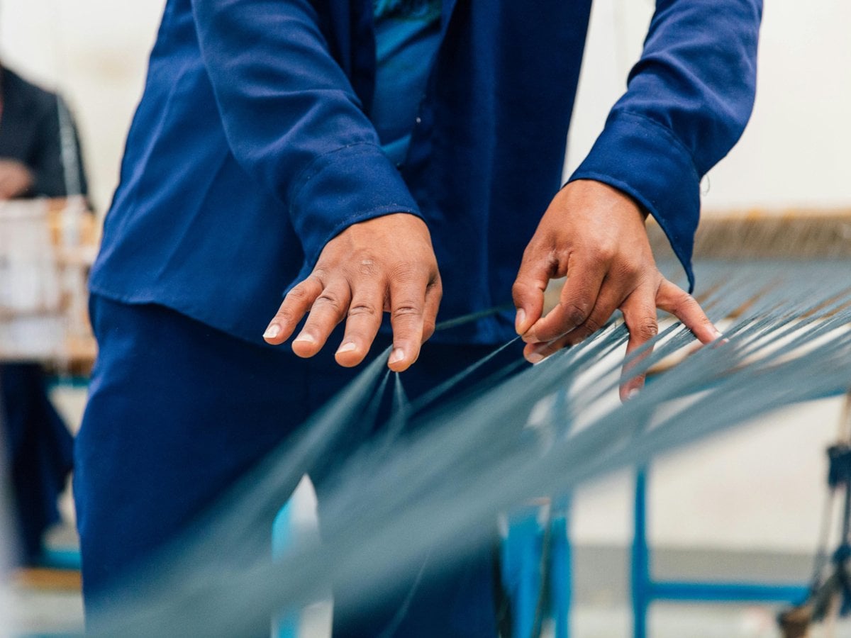 Bilden visar händer på en person som väver 