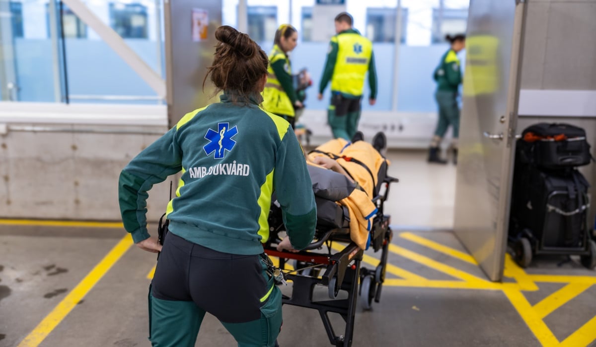 En kvinna som skjuter en vagn full med bagage.