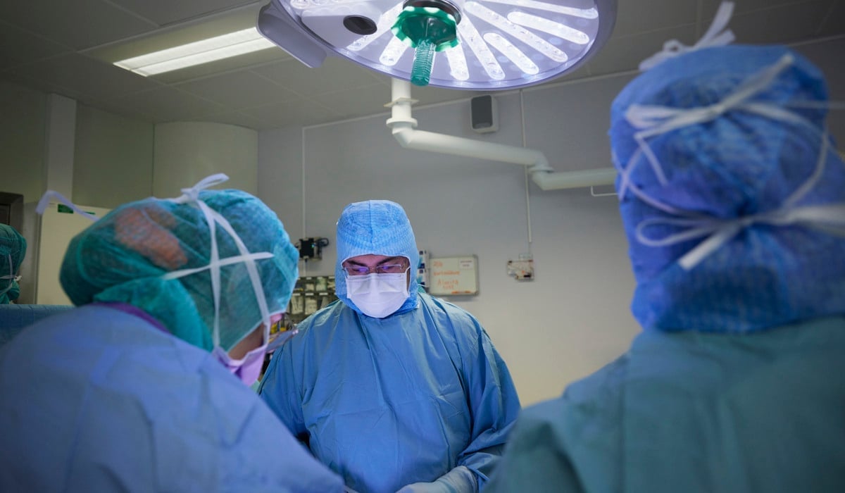 En grupp läkare i operationskläder i ett rum.