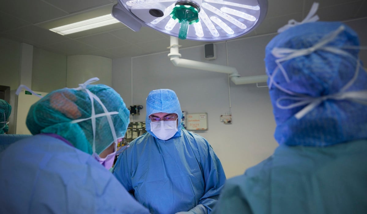 En grupp läkare i operationskläder i ett rum.