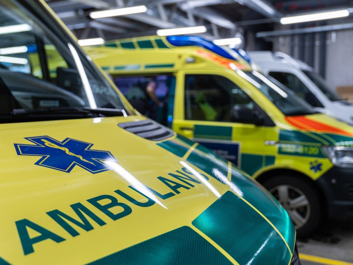 Ambulanser parkerade i en lagerlokal med utryckningsfordon.