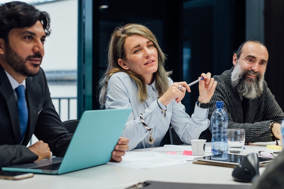 Två män och en kvinna vid ett skrivbord 