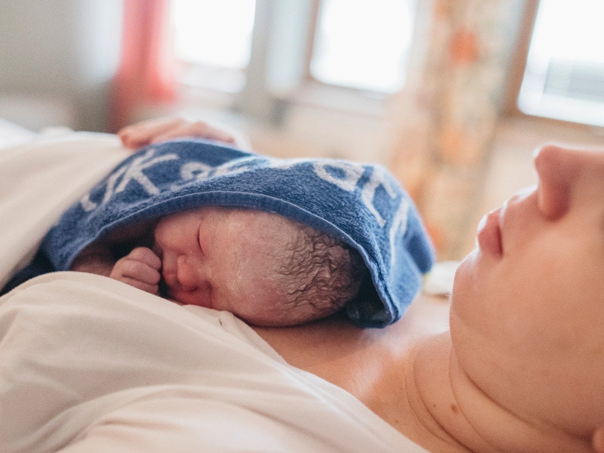 Nyfödd bebis på mammas bröst