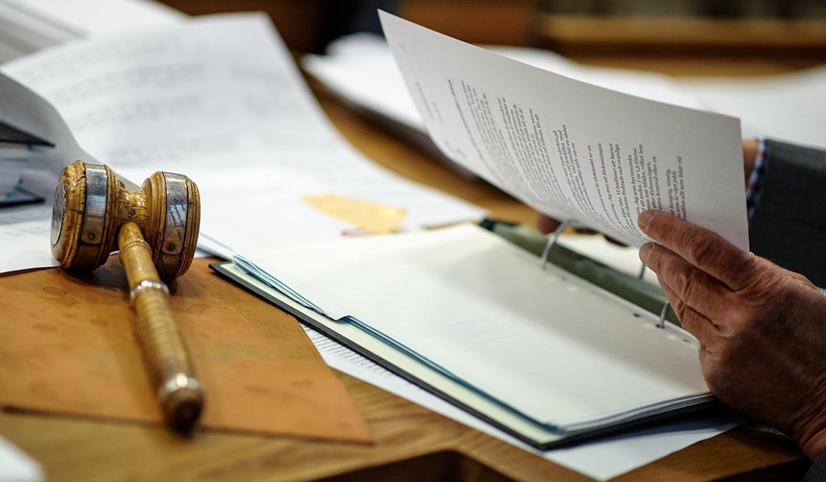 Beslutsklubba och person som går igenom handlingar