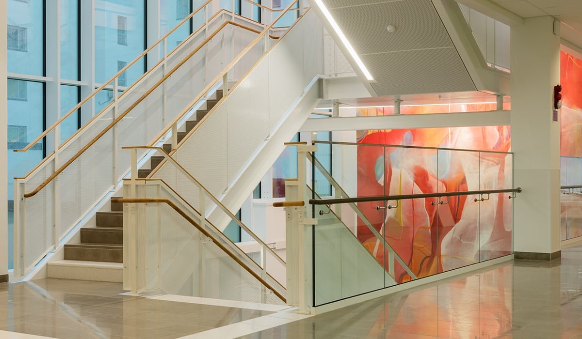 Trapphus med konstverk på vägg utmed alla våningsplan. Graffittiinspirerad målning.