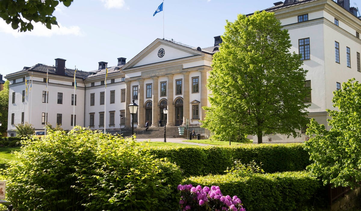 Landstingshuset omgiven av lummiga gröna träd.