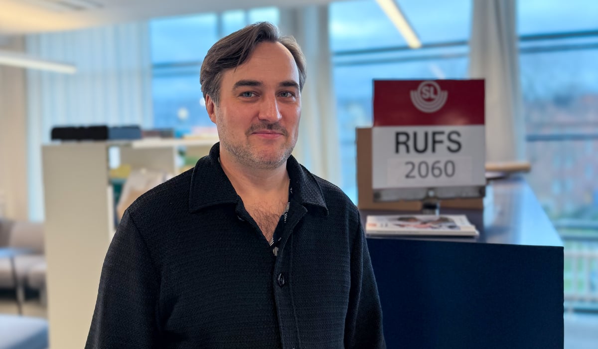 En man som står på ett kontor med händerna i fickorna.