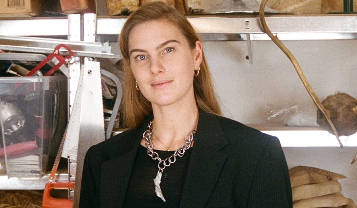 Konstnären Ellen Hedin, framför en hylla med slöjdmaterial.