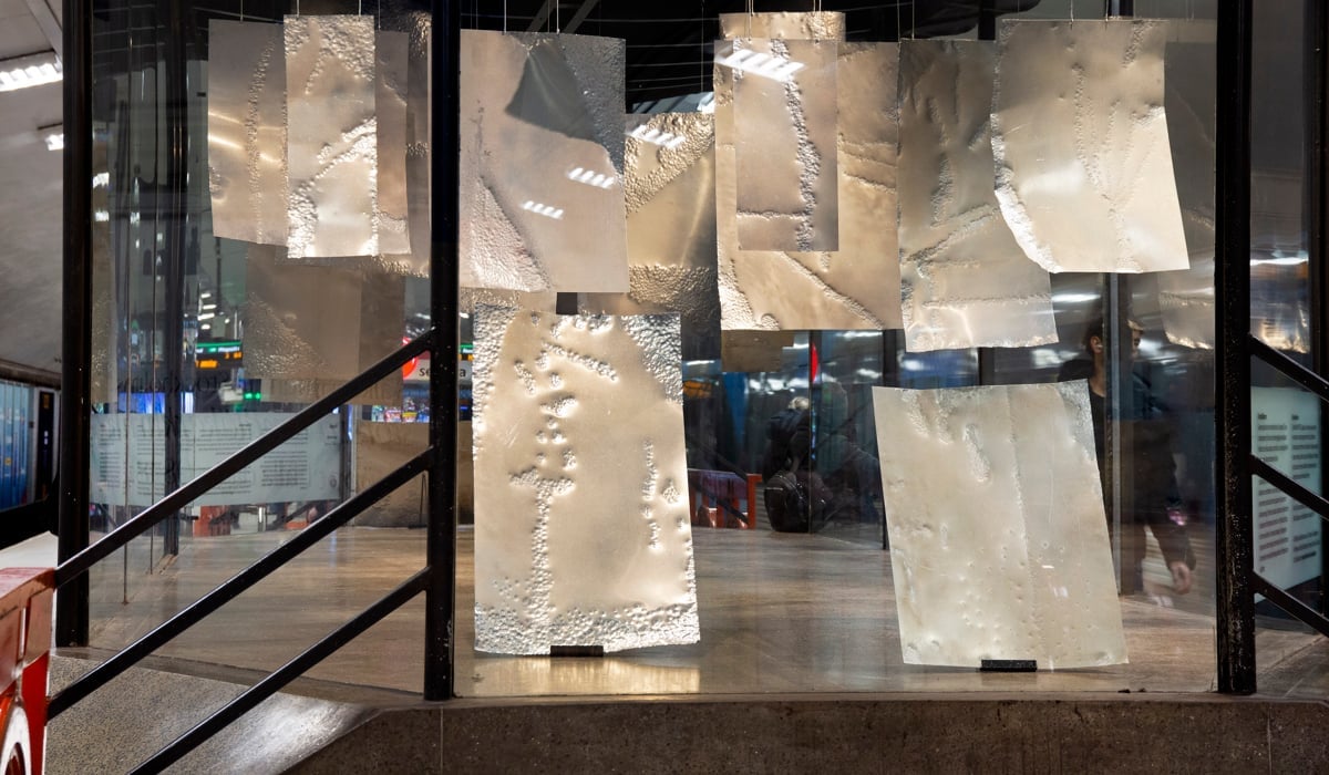 metallplåtar som hänger från taket i montern. Plåtarna har fått mönster av droppande vatten och salt.