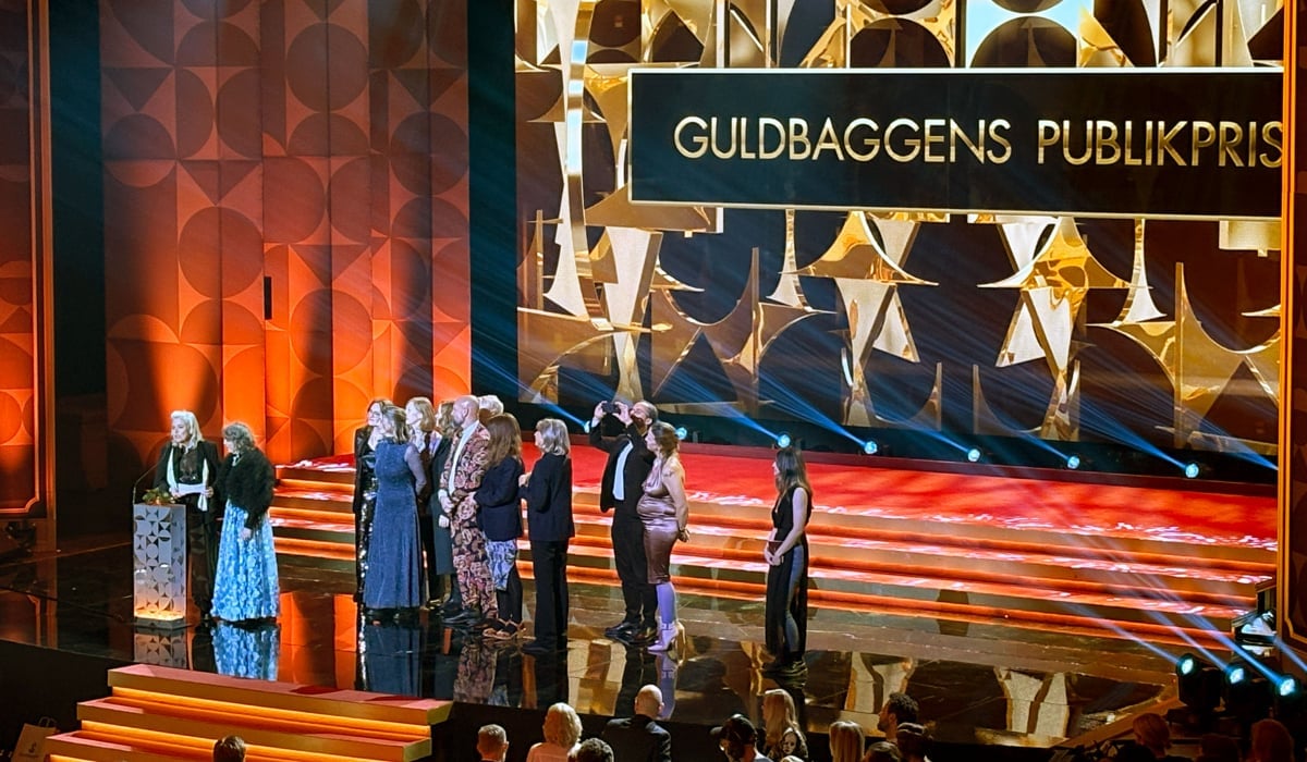 Glada personer på scen med texten Guldbaggens publikpris i bakgrunden.