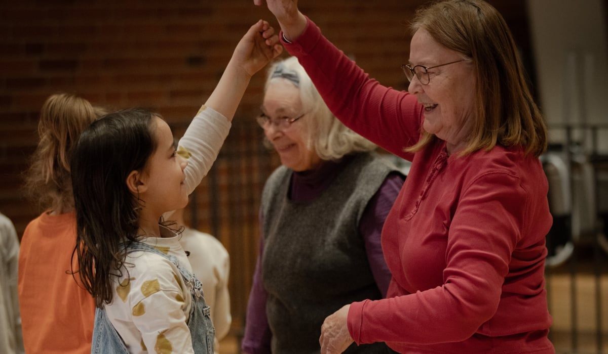 Barn och seniorer som dansar med varandra