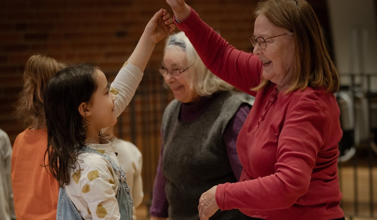 Barn och seniorer som dansar med varandra
