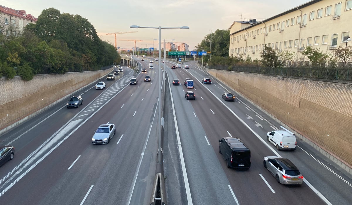 En motorväg med mycket trafik bredvid höga byggnader.