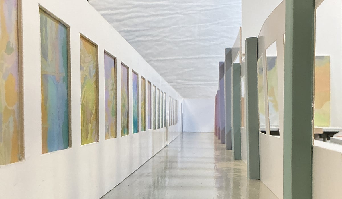 Modell av en lång korridor med målningar på väggarna.