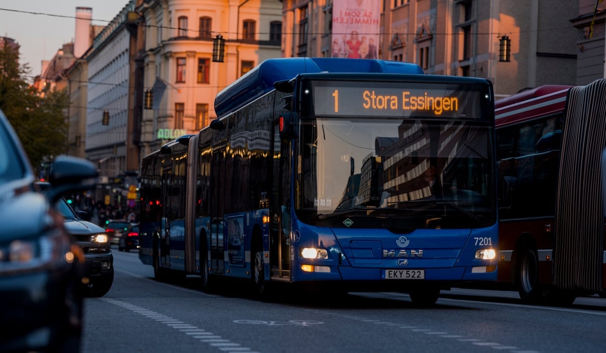 Solnedgång i centrala Stockholm reflekterar sig mot den blåa bussen