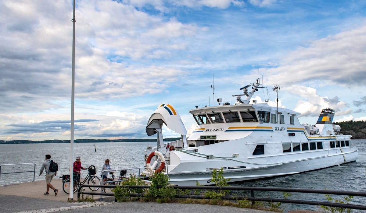 En grupp människor som står på en pir bredvid en båt.