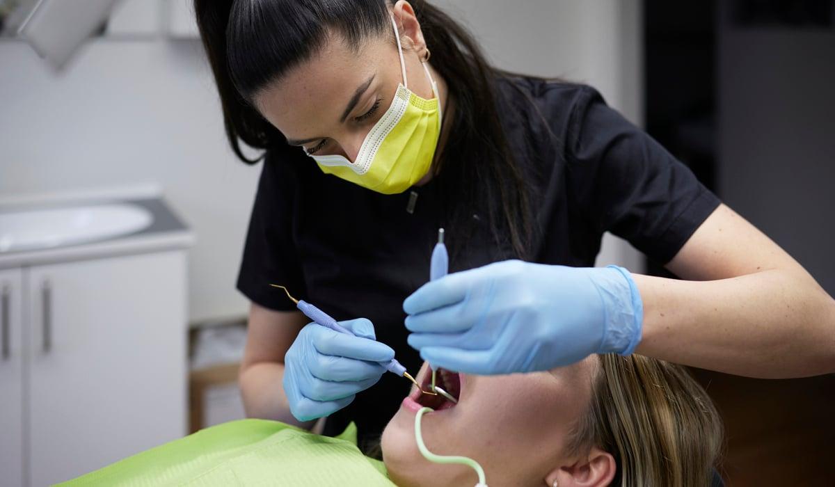 Foto på en tandläkare som undersöker en patient. 