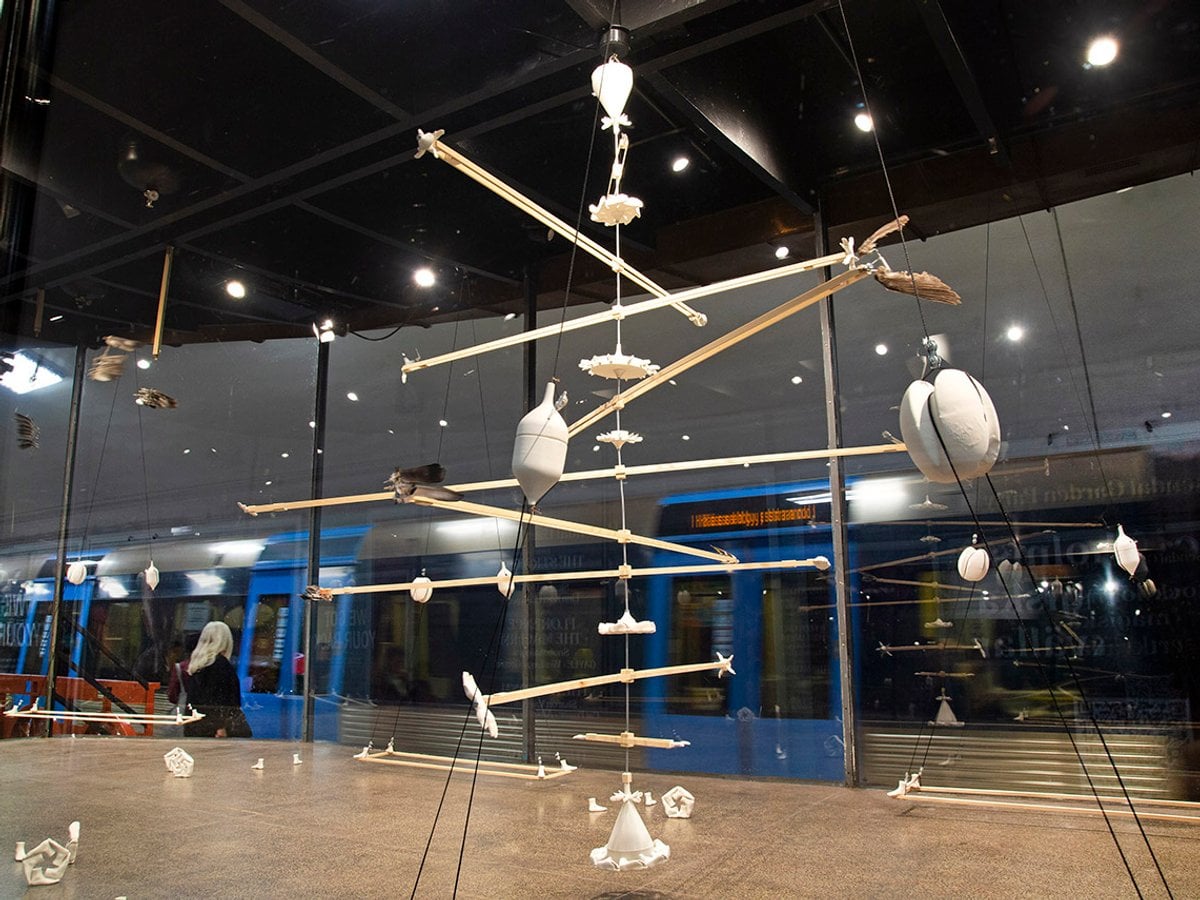 Hängande porslinsobjekt i mobiler hänger i taket i montern.