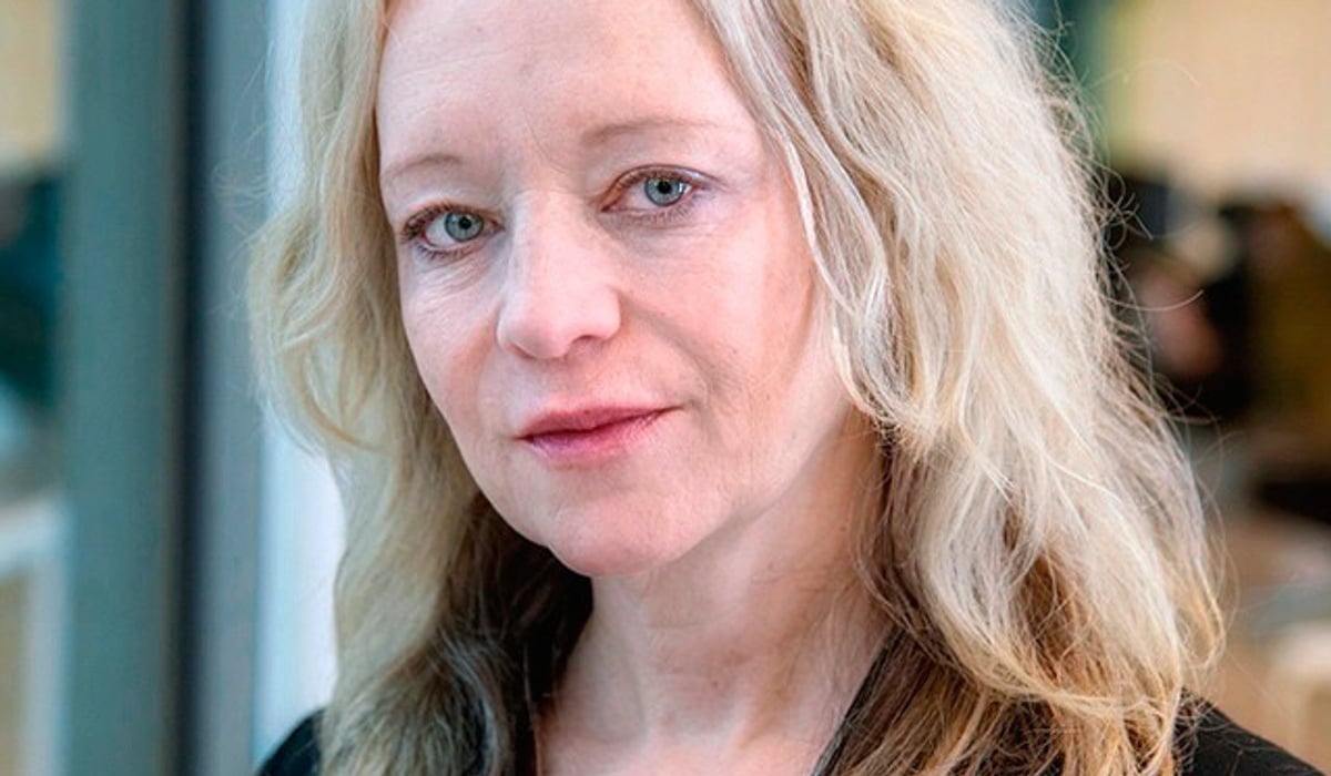 En kvinna med blont hår och svart skjorta.