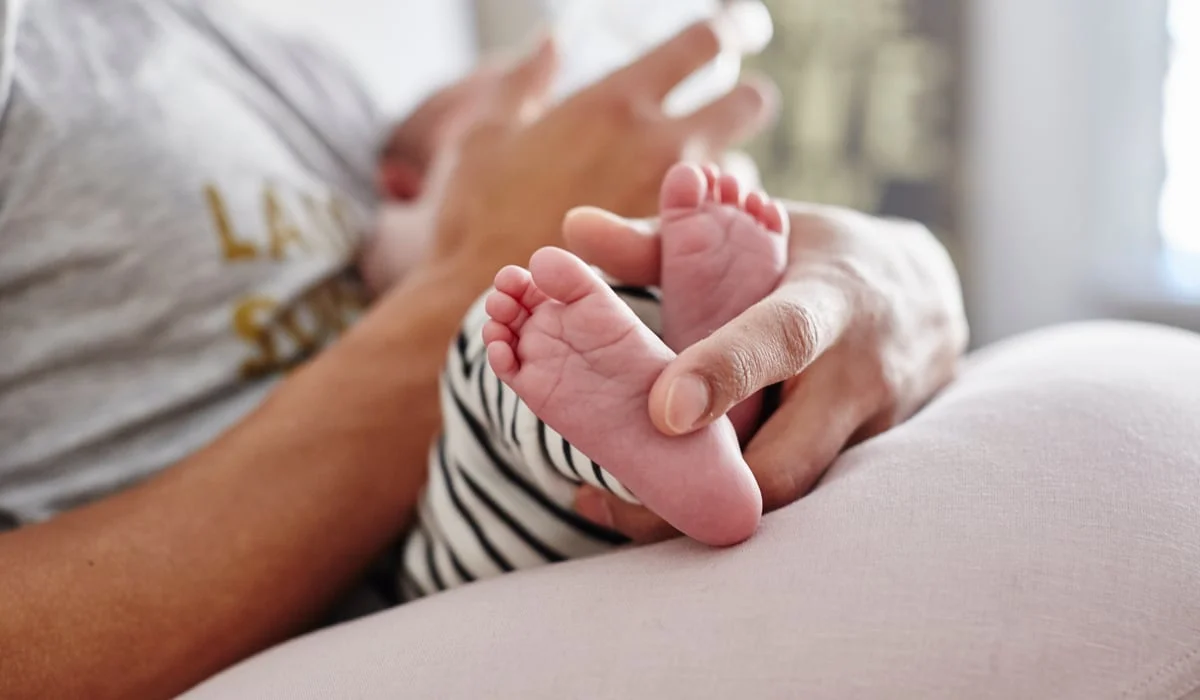 En person som håller en bebis i famnen.