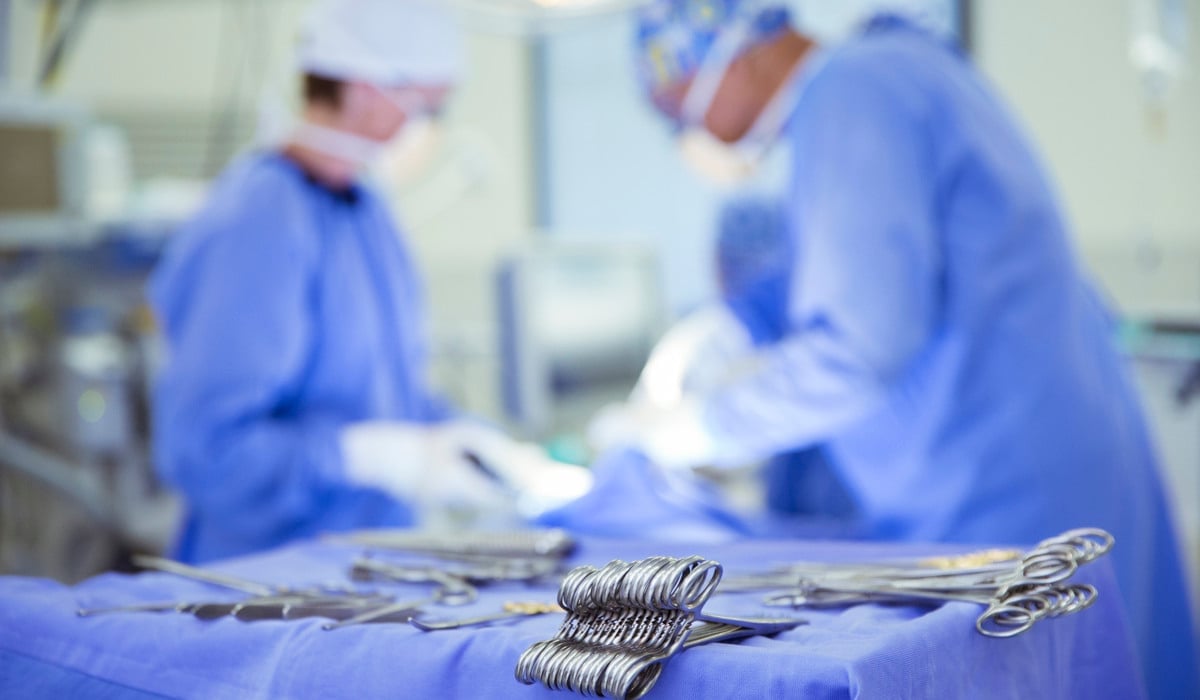 Två kirurger i en operationssal med kirurgisk utrustning.