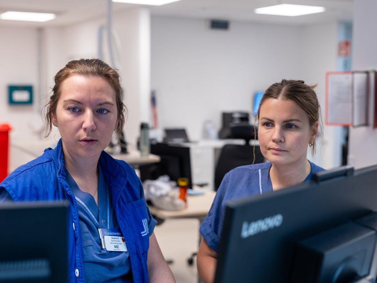 Två kvinnor i hälso- och sjukvården framför datorer