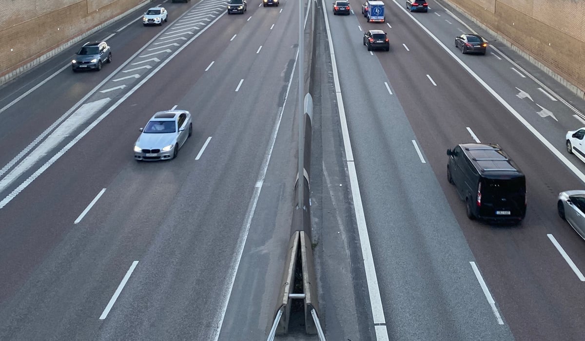 En motorväg med mycket trafik bredvid höga byggnader.