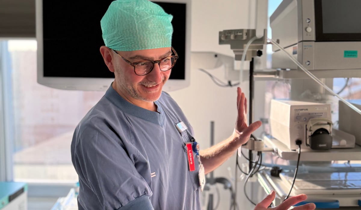 En man i operationskläder står i ett sjukhusrum.