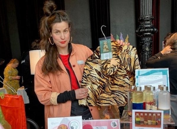 Bibliotekarie bakom ett mässbord håller upp en tigerdräkt.