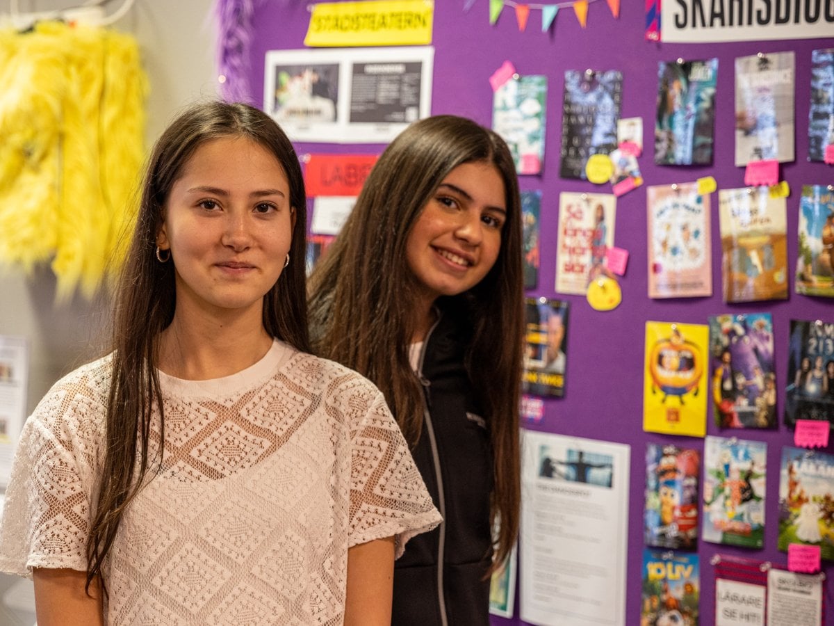 Två tjejer framför en anslagstavla i en biograffoajé