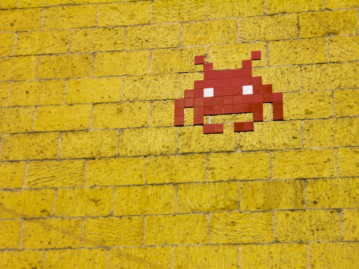 Gul tegelvägg med röd spelfigur på