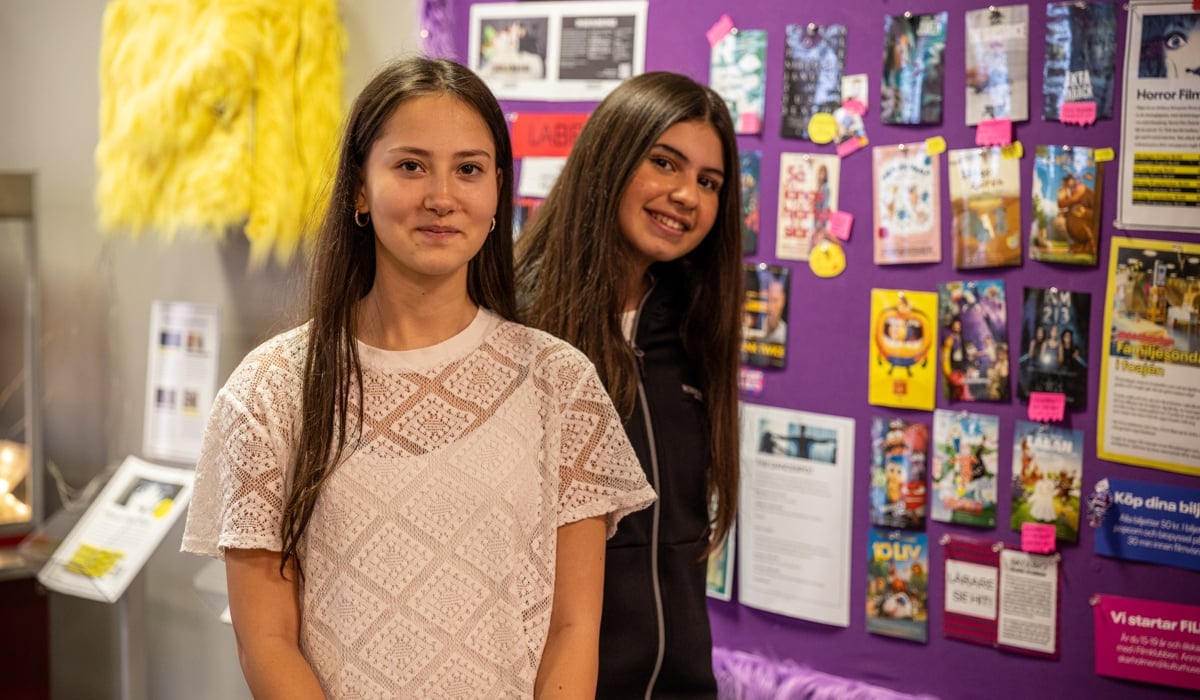 Två tjejer framför en anslagstavla i en biograffoajé