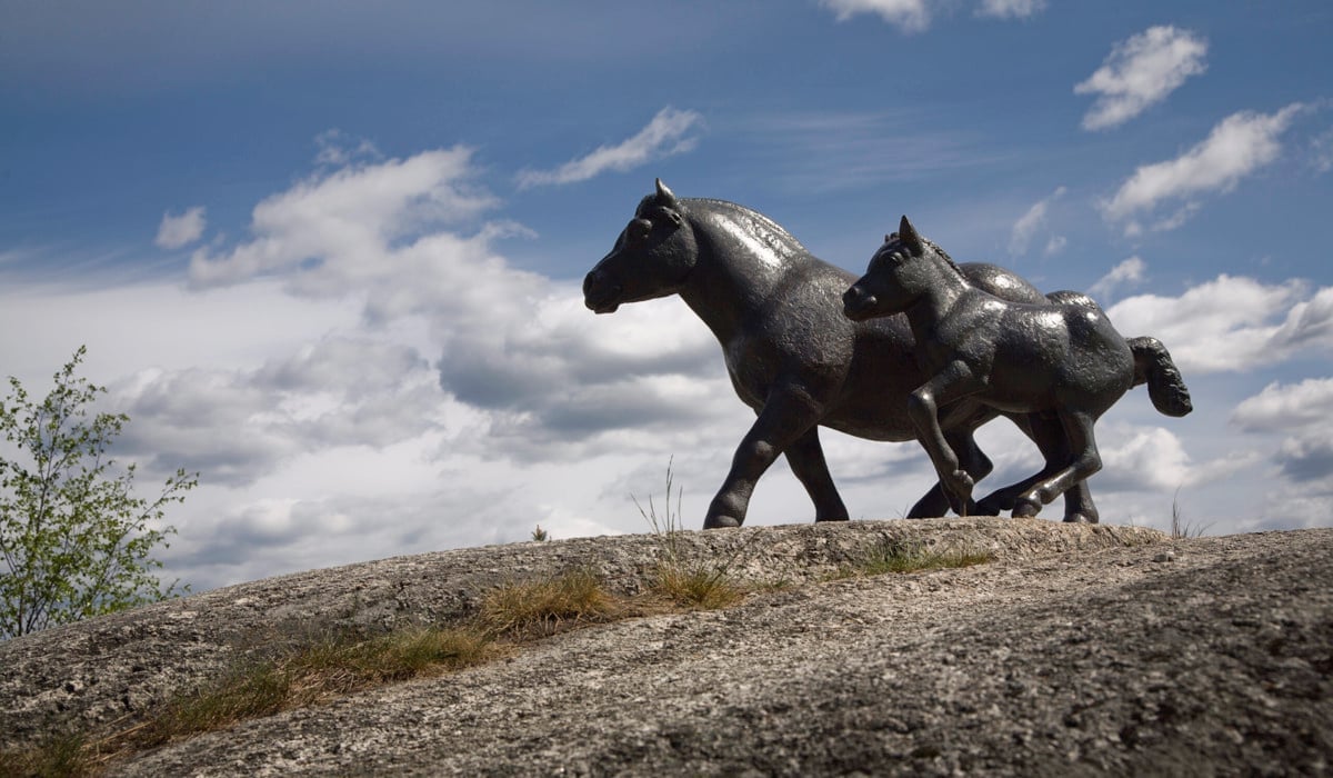 Två skulpturer av hästar på berg.